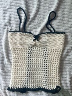 a crocheted bag with black and white stripes on the bottom, tied to a string