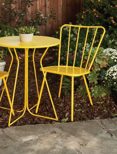 two yellow chairs sitting next to each other in front of a table and chair set