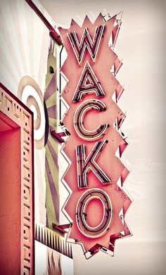 a neon sign that says wacko on the side of a building