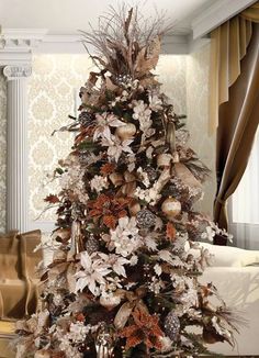 a decorated christmas tree in the middle of a living room with gold and white decor