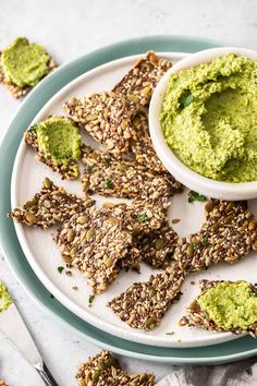 a white plate topped with crackers and guacamole