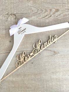 a wooden sign that says mr and mrs on it with a bow hanging from the hanger