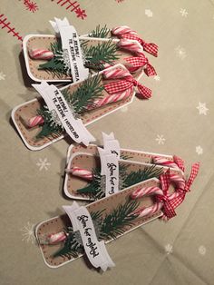 three candy canes are wrapped in paper and tied with ribbon on top of each other