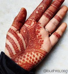 a person's hand with red henna on top of their palm and fingers