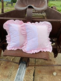 two pink pillows sitting on top of an old wagon