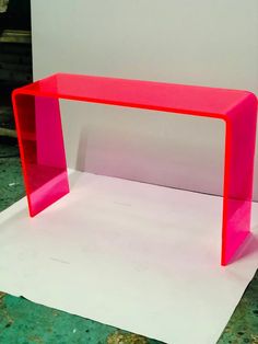 a pink shelf sitting on top of a piece of paper