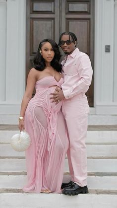 a man and woman in formal wear standing on steps