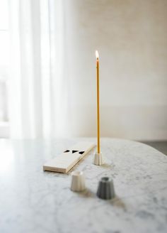 a candle on a table next to a book