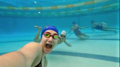 two people swimming in a pool with goggles on and one person wearing a swim cap