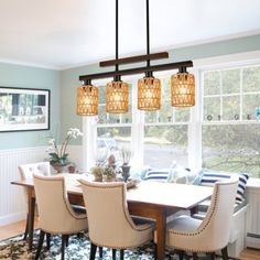 a dining room table with four chairs and a chandelier hanging from the ceiling