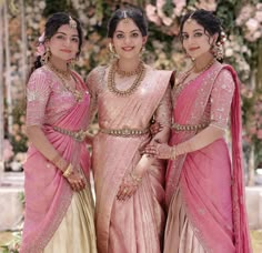 three women in pink and gold outfits posing for the camera