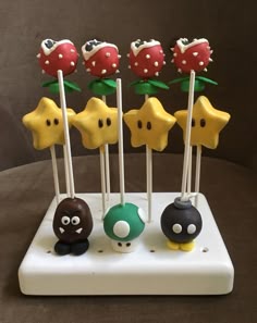 there are some cake pops that look like mario bros and other characters on the stick