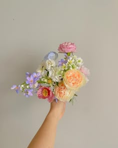 a hand is holding a bouquet of flowers