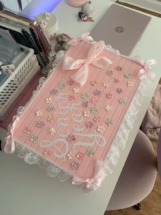 a pink birthday cake sitting on top of a table