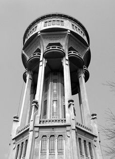 a tall building with a clock on the top of it's face and windows