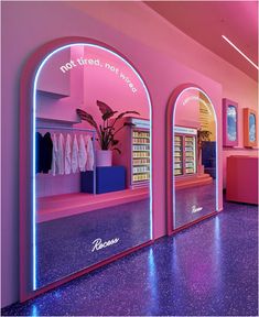 the interior of a store with pink walls and arched doorways that have neon lights on them