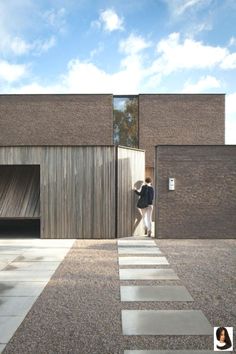 a person standing in front of a brick building with a door open to the outside