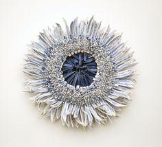 a blue and white brooch sitting on top of a white table next to a wall