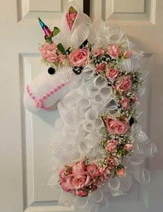 a white door with a pink unicorn head and flowers on it