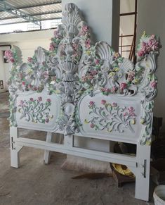 an ornate white bench with pink flowers on it