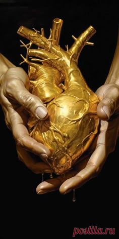 two hands holding a gold heart in the shape of a human heart, against a black background