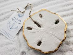 a white and gold sand dollar ornament sitting on top of a towel