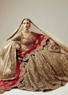 a woman in a bridal gown sitting on the floor with her veil over her head