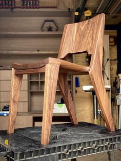 a wooden chair sitting on top of a piece of metal in a room filled with cabinets