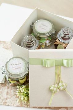 an open gift box filled with cookies and candies on top of a lace tablecloth