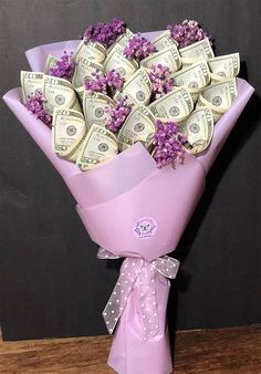 a bouquet of money wrapped in pink paper