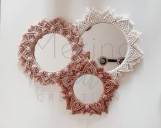 two circular mirrors are hanging on the wall next to each other, one is made from crocheted yarn