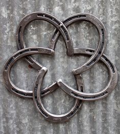 four horseshoes are arranged in the shape of an eight - pointed flower on a concrete surface