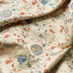 an image of a flowery fabric with red, blue and green flowers on it