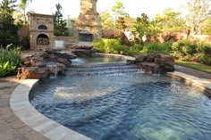 an outdoor swimming pool with waterfall and fire place