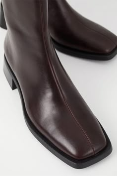 Vagabond Blanca square toe boots in beautiful chocolate brown leather. The smooth leather upper is set on contrast-colored outsoles, complemented with flared block heels for a contemporary look. The square toes and mid-shaft provides a modern, refined take on a classic style. Details include zip-side fastening and visible seams along the front. True to size Shaft height: 189 mm, shaft width: 253 mm, heel height: 47 mm 5217-201-35 PIPE AND ROW Vagabond Shoes, Clogs Heels, Neutral Shoes, Style Goals, Chocolate Leather, Cream Shoes, Square Toe Boots, Toe Boots, Goat Leather