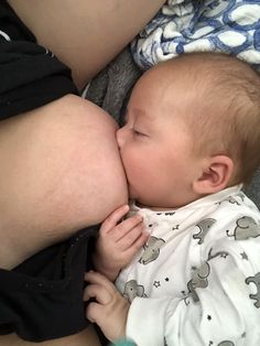 a baby is laying down and kissing the belly of an adult