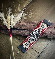 a pair of scissors sitting on top of a piece of wood next to some dry grass