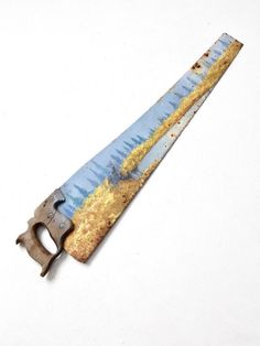 an old metal object that looks like it has been painted blue and yellow with gold streaks