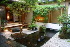 a japanese garden with rocks and trees in the center, lit up by lights at night