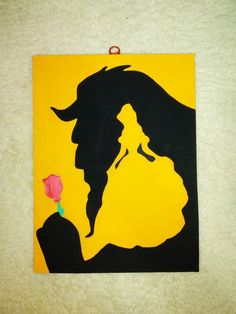 the silhouette of a woman holding a rose on a yellow and black paper cutout