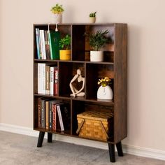 a book shelf with books and plants on it