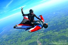 a man flying through the air while riding a parachute