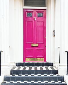 a bright pink door with black and white checkered steps