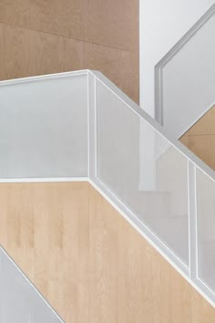 an overhead view of a staircase with white mesh railings and wood paneling on the wall