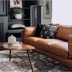 a living room filled with furniture and a fire place in front of a large window