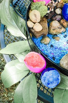 an outdoor table with rocks and plants on it