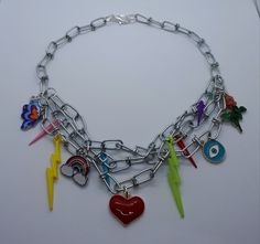 Checkout  my handmade  colourful muti charm necklace! Made with a chunky silver stainless steel chain x 3 chains.  Charms to make you smile with this happy go lucky theme 😁 please note lighting bolt colours are picked at random. Also available in a textured gold coloured stainless steel chain! The picture of the chains may not be a true representation of the colour as this very much depends on the camera and the lighting. The length of this necklace  is  approximately 17ins. Can come with exten Chunky Charm Necklace, Kidcore Necklace, Mens Necklace Fashion, Chained Necklace, Spiked Jewelry, Lighting Bolt, Happy Go Lucky, Necklace Outfit, Upcycle Clothes Diy