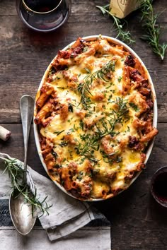 a casserole with meat, cheese and herbs in a white dish on a wooden table