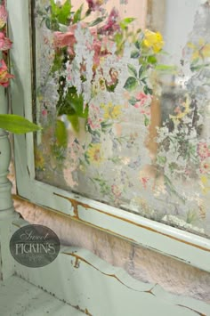 a vase with flowers in it sitting next to a window