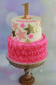 a pink and white cake with gold stars on top